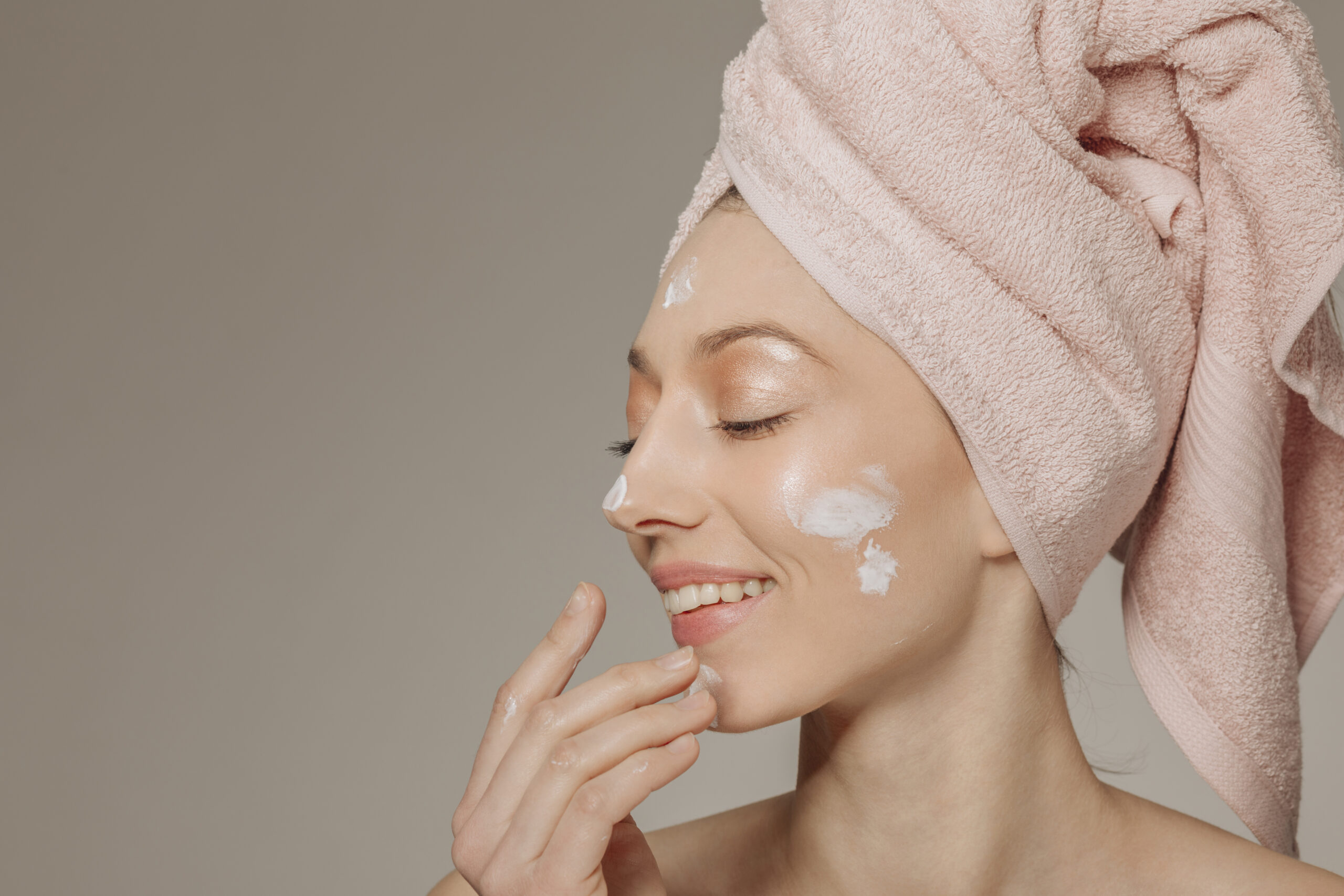 Girl with towel head using lotion