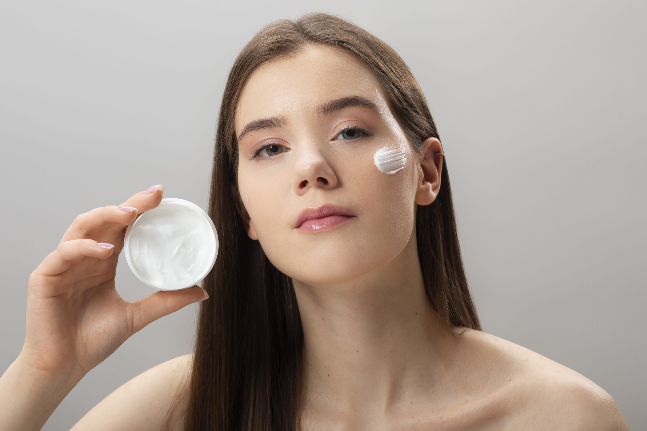 Medium shot woman holding cream container
